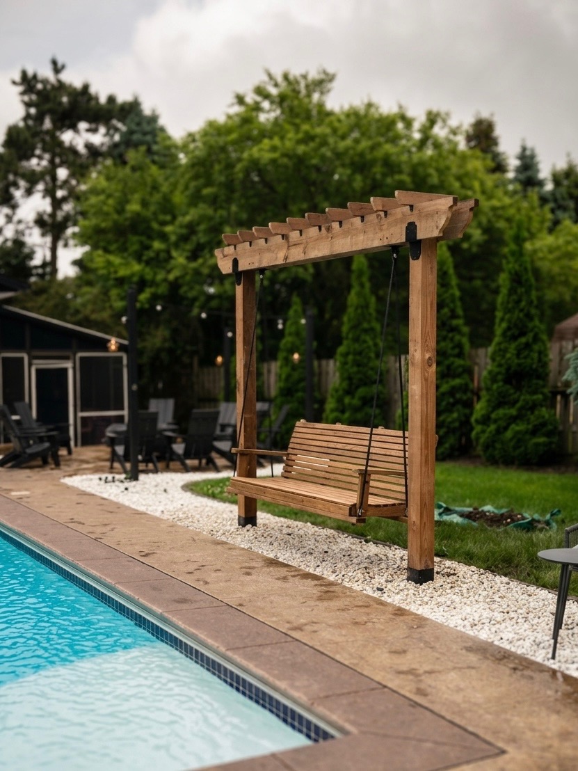 Cedar pergola swing set poolside on a bed of white river stone